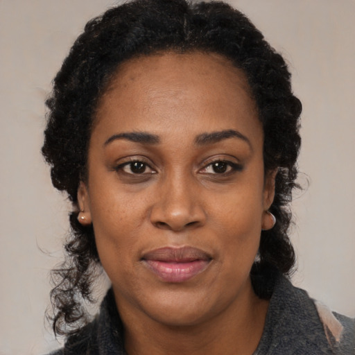 Joyful black adult female with medium  black hair and brown eyes