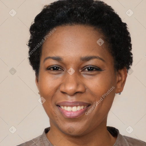 Joyful black adult female with short  black hair and brown eyes