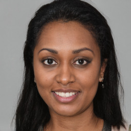 Joyful latino young-adult female with long  brown hair and brown eyes