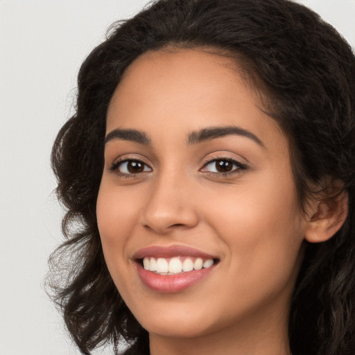 Joyful latino young-adult female with long  brown hair and brown eyes