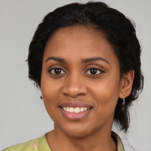 Joyful black young-adult female with long  black hair and brown eyes