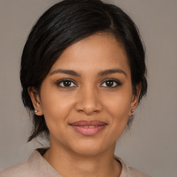 Joyful black young-adult female with medium  brown hair and brown eyes