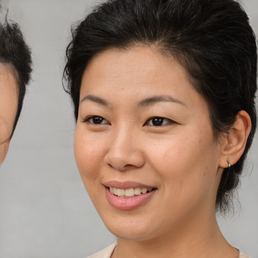 Joyful asian young-adult female with medium  brown hair and brown eyes