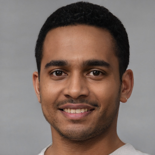 Joyful latino young-adult male with short  black hair and brown eyes