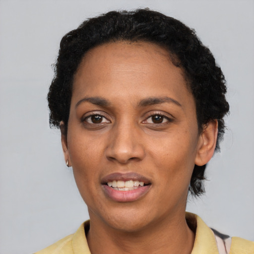 Joyful black adult female with short  black hair and brown eyes