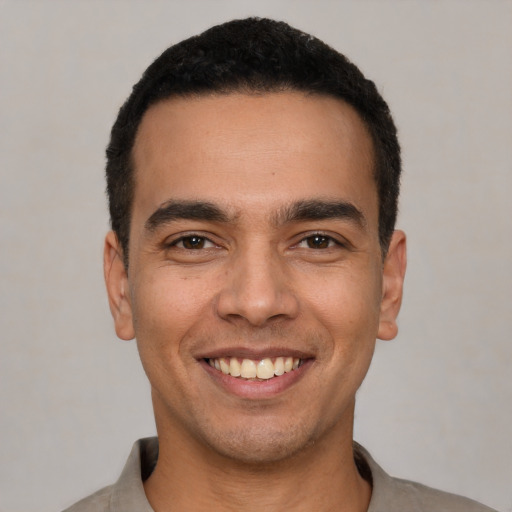 Joyful white young-adult male with short  black hair and brown eyes