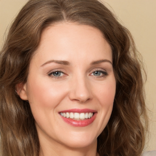 Joyful white young-adult female with long  brown hair and green eyes