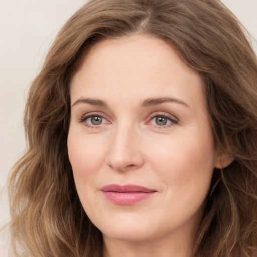 Joyful white young-adult female with long  brown hair and green eyes