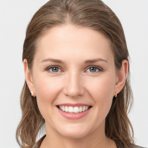 Joyful white young-adult female with long  brown hair and grey eyes