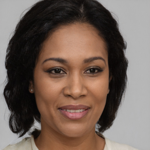 Joyful black adult female with medium  brown hair and brown eyes