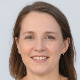 Joyful white adult female with long  brown hair and grey eyes