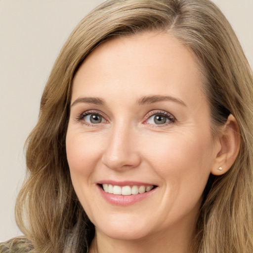 Joyful white adult female with long  brown hair and green eyes