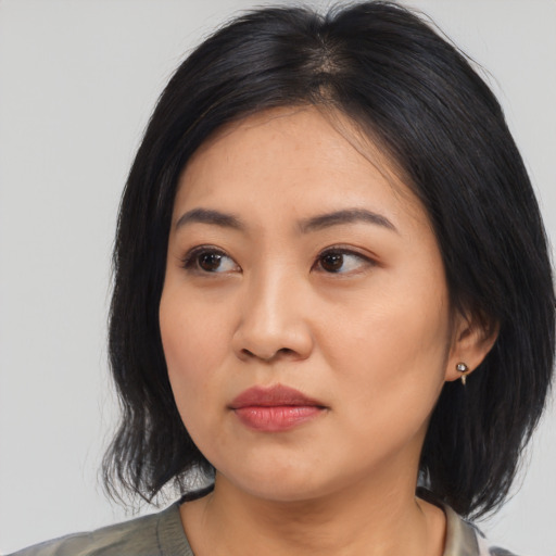 Joyful asian young-adult female with medium  black hair and brown eyes