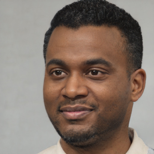 Joyful black young-adult male with short  black hair and brown eyes