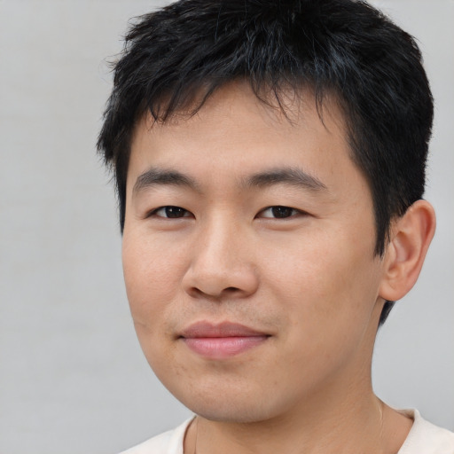 Joyful asian young-adult male with short  black hair and brown eyes