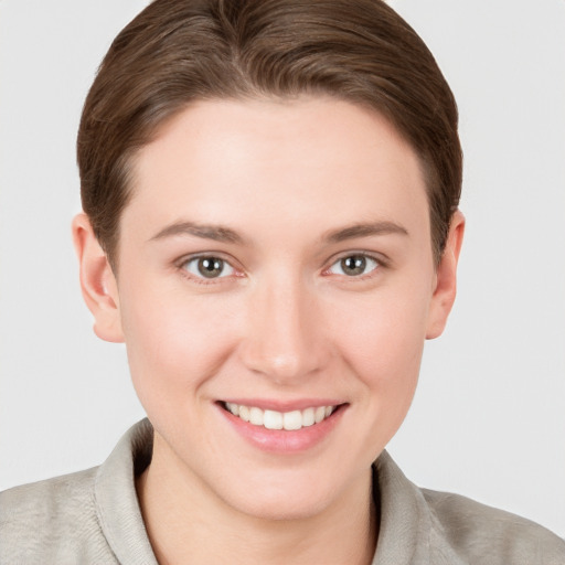 Joyful white young-adult female with short  brown hair and grey eyes