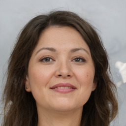 Joyful white adult female with long  brown hair and brown eyes