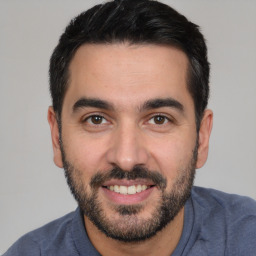 Joyful white young-adult male with short  black hair and brown eyes