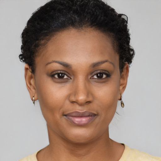 Joyful black young-adult female with short  brown hair and brown eyes