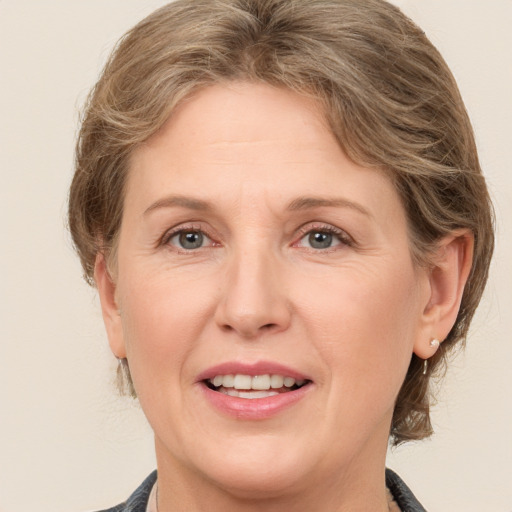 Joyful white adult female with medium  brown hair and grey eyes