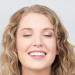 Joyful white young-adult female with long  brown hair and blue eyes