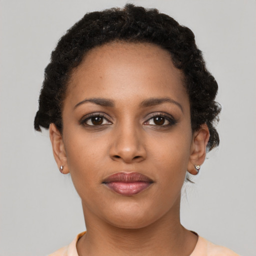 Joyful black young-adult female with short  brown hair and brown eyes