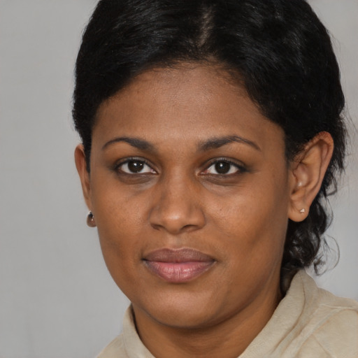Joyful black young-adult female with short  black hair and brown eyes