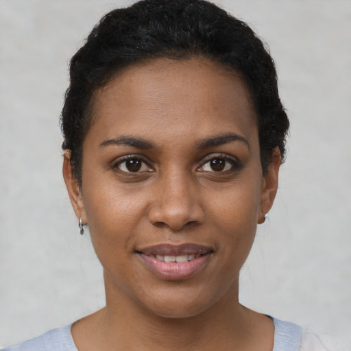 Joyful black young-adult female with short  brown hair and brown eyes