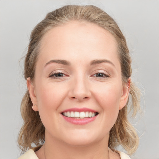 Joyful white young-adult female with medium  brown hair and grey eyes