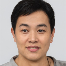 Joyful asian young-adult male with short  brown hair and brown eyes