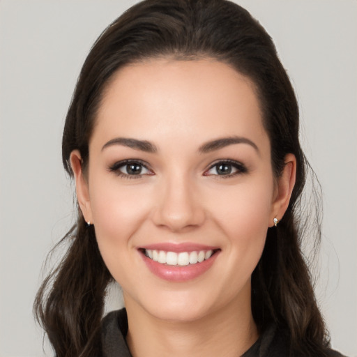 Joyful white young-adult female with long  brown hair and brown eyes