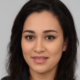 Joyful latino young-adult female with long  brown hair and brown eyes