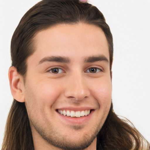 Joyful white young-adult male with long  brown hair and brown eyes