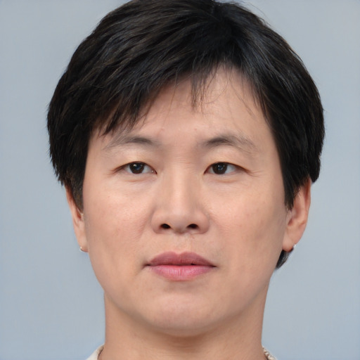 Joyful asian adult male with short  brown hair and brown eyes