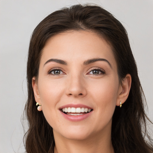 Joyful white young-adult female with long  brown hair and brown eyes