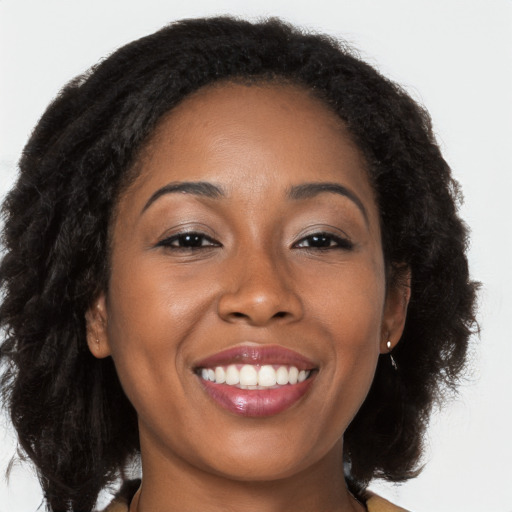 Joyful black young-adult female with long  brown hair and brown eyes