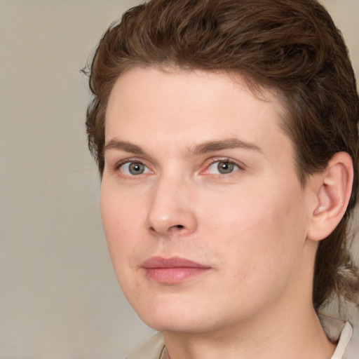 Joyful white young-adult male with medium  brown hair and grey eyes