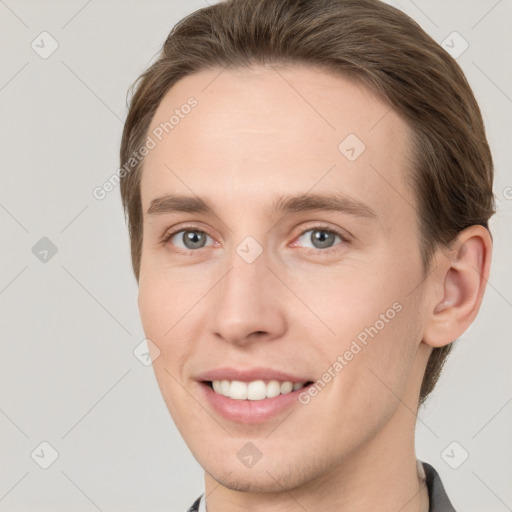 Joyful white young-adult male with short  brown hair and grey eyes