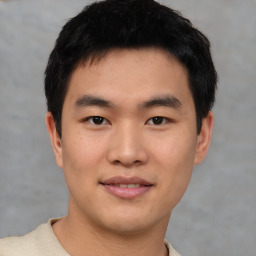 Joyful asian young-adult male with short  black hair and brown eyes