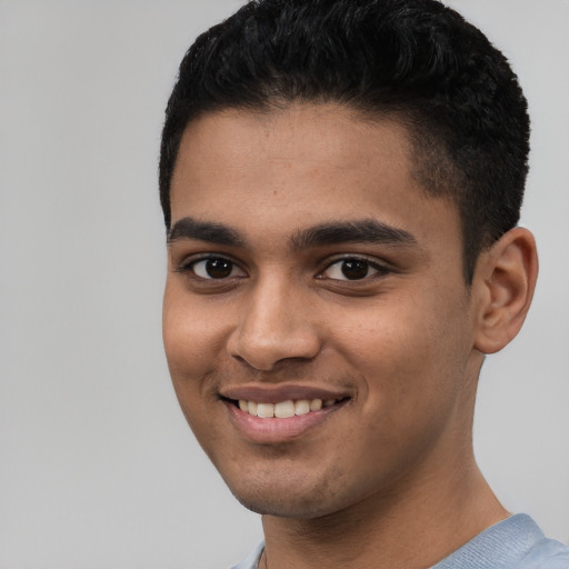 Joyful latino young-adult male with short  brown hair and brown eyes