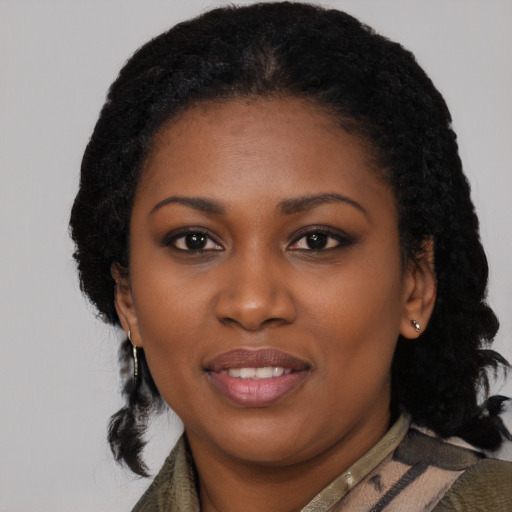 Joyful black young-adult female with long  black hair and brown eyes