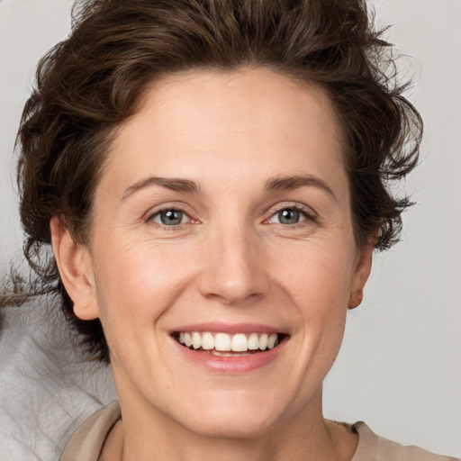 Joyful white adult female with medium  brown hair and grey eyes