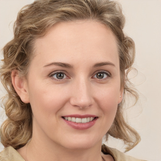 Joyful white young-adult female with medium  brown hair and blue eyes