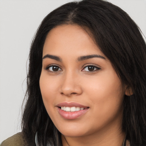 Joyful latino young-adult female with long  brown hair and brown eyes