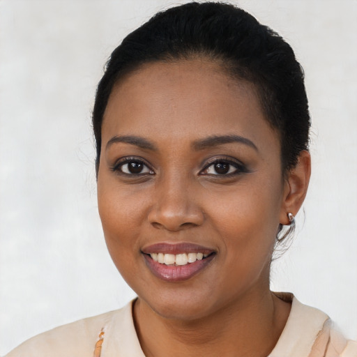 Joyful black young-adult female with short  black hair and brown eyes
