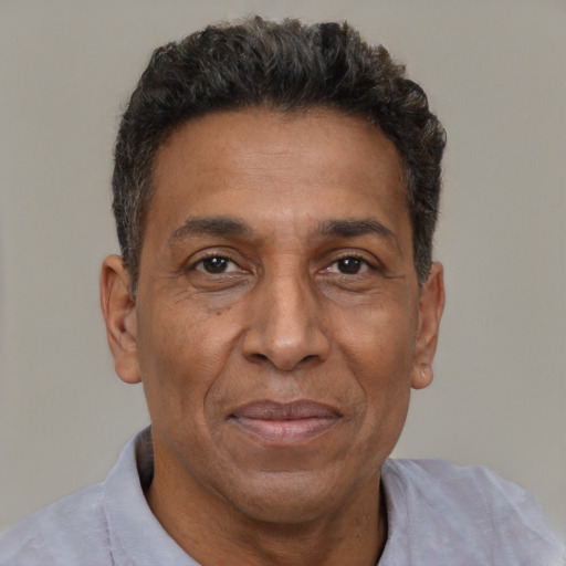 Joyful black adult male with short  brown hair and brown eyes