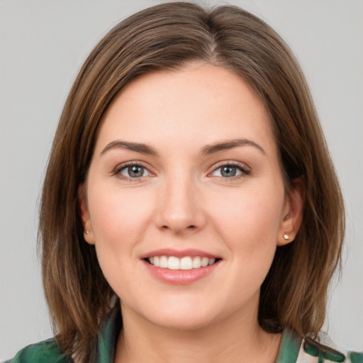 Joyful white young-adult female with medium  brown hair and green eyes