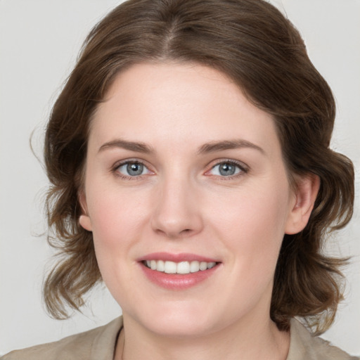 Joyful white young-adult female with medium  brown hair and grey eyes