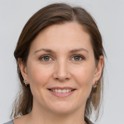 Joyful white young-adult female with medium  brown hair and grey eyes