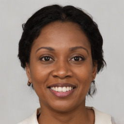 Joyful black adult female with medium  brown hair and brown eyes